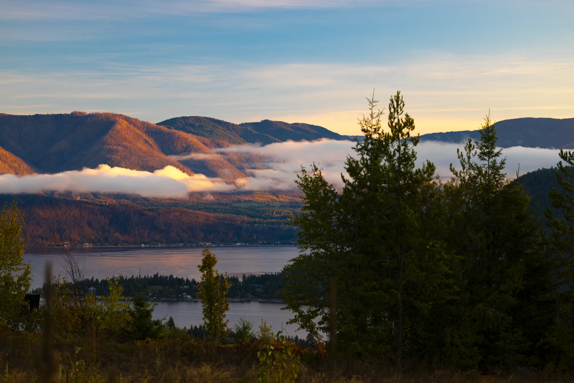 Best places to retire in BC: morning fog on Shuswap Lake below the mountains, seen from The Highlands at Blind Bay